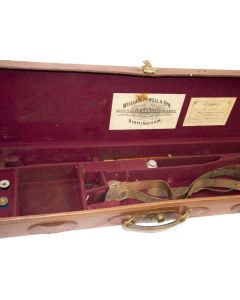William Powell tan leather shotgun case with brass fittings on bench

